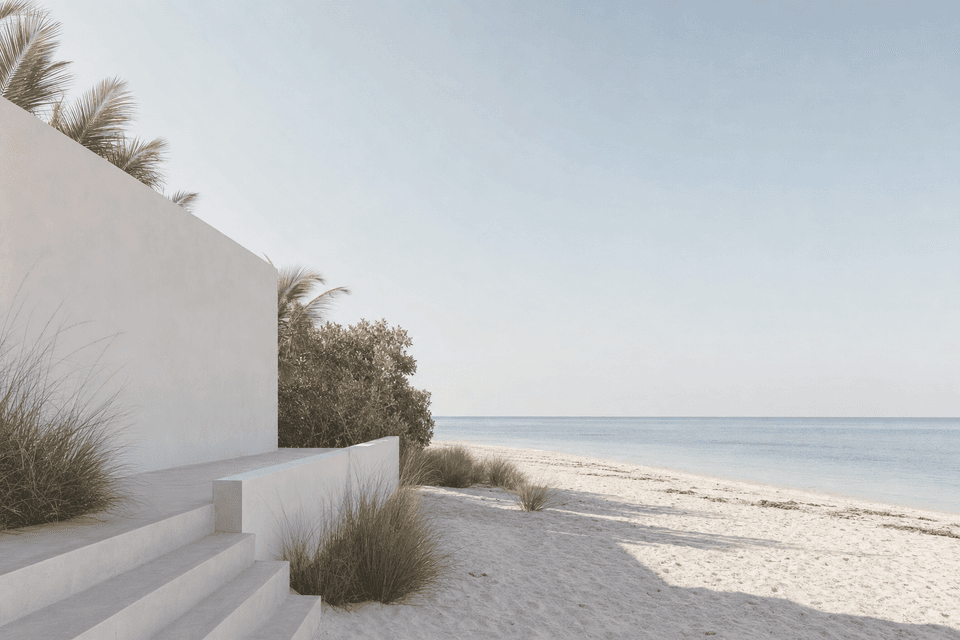 White plaster steps running down through dune grass onto pale sand, with the sea beyond.
